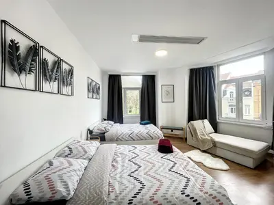 a bedroom with a bed and a couch and a chair at Hypercentre 4 in Brussels
