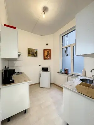 a kitchen with white cabinets and a sink and a window at Hypercentre 4 in Brussels