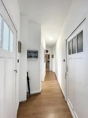 a hallway with white walls and a wooden floor at Hypercentre 4 in Brussels