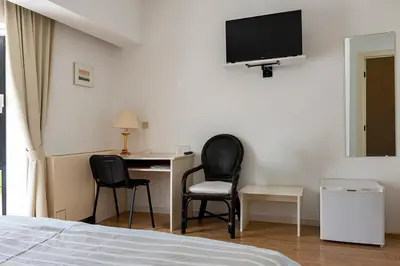 a bedroom with a bed and a desk and two chairs at De Witte Meren in Keerbergen
