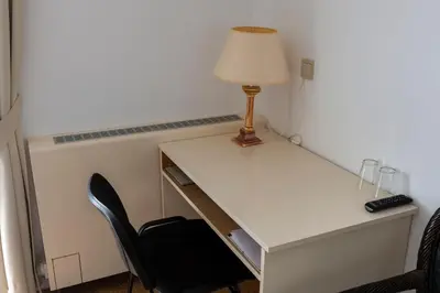 a desk with a lamp and a chair at De Witte Meren in Keerbergen