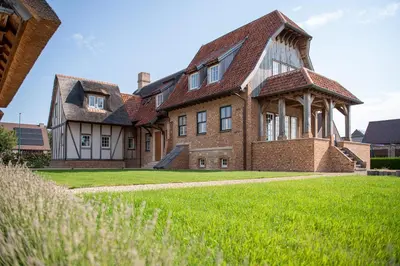 a large brick house with a large lawn at Anno 1673 in Evergem