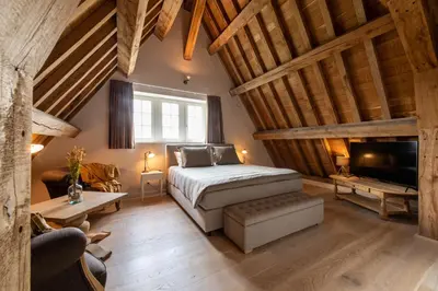 a bedroom with a bed and a tv in a room at Anno 1673 in Evergem