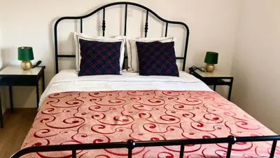 a bedroom with a bed with a red and white bedspread at Orange Dolce in Zaventem
