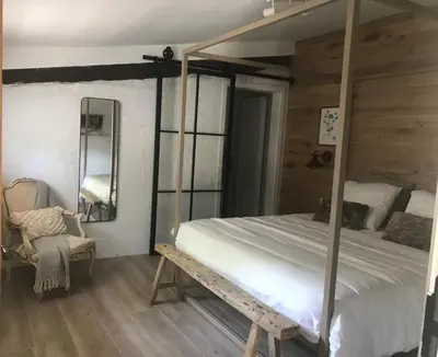 a bedroom with a canopy bed and a chair at Ons Hofke in Lubbeek