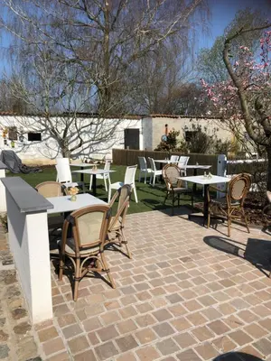 a patio with tables and chairs on a brick patio at Ons Hofke in Lubbeek