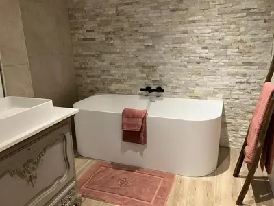 a bathroom with a white tub and a sink at Ons Hofke in Lubbeek