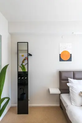 a room with a mirror next to a bed at Japie rooms - in the heart of Antwerp in Antwerp