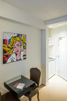 a living room with a table and a painting on the wall at Japie rooms - in the heart of Antwerp in Antwerp