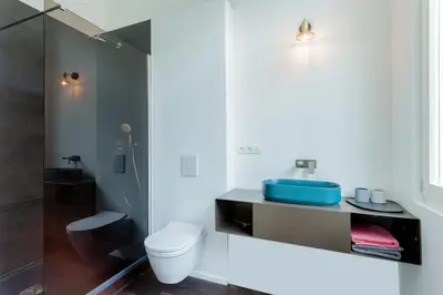 a bathroom with a toilet and a blue sink at RODELIJV in Ghent