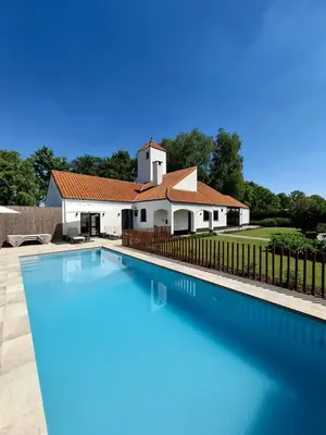 a swimming pool in front of a house at Landhuys Odette in Retie