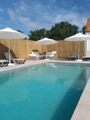 a swimming pool with chairs and umbrellas at Landhuys Odette in Retie