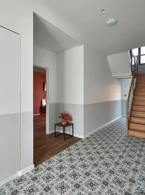 a hallway with a staircase and a table with flowers at Kamerrijk in Pepingen