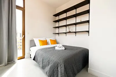 a bedroom with a bed with orange pillows at Luxury Suites South by Rikas Hotels in Antwerp