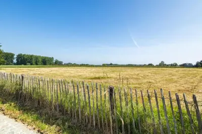 a fence in front of a field of grass at Burgemeestershof in Wetteren