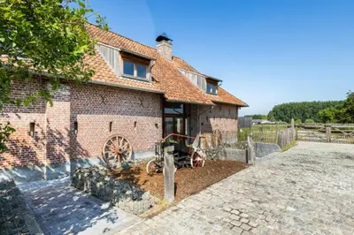 a brick house with a wheel in front of it at Burgemeestershof in Wetteren