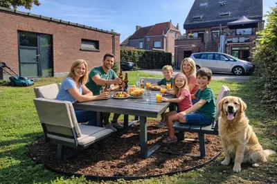 a family sitting at a picnic table with a dog at Penthouse 40 m2 in Zemst