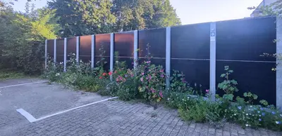 a fence with a bunch of flowers in a parking lot at Penthouse 40 m2 in Zemst