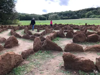 two people walking in a field with large rocks at Linden-Jachthoorn in Lubbeek