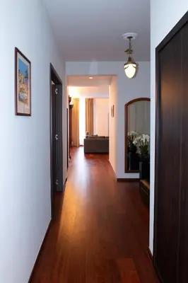a living room with a hard wood floor and a hallway at Botanique Suites AirBnB, Antwerp in Antwerp