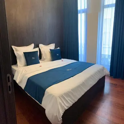 a large bed with blue and white sheets and pillows at Botanique Suites AirBnB, Antwerp in Antwerp