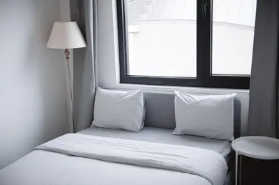 a bed sitting in a room with a window at K&Y suite 1 Brussels airport 500m! in Zaventem