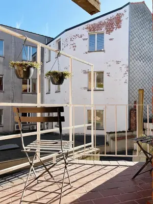 a chair sitting on a patio in front of a building at Trendy & sunny apartment in Ghent in Ghent