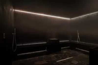 a dark room with a bench and a light on the wall at Mix Brussels --Gym & Wellness for adults only-- in Brussels