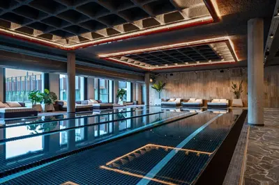 a swimming pool with chairs and tables in a building at Mix Brussels --Gym & Wellness for adults only-- in Brussels