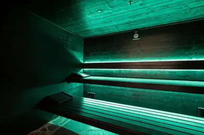 a dark room with a bench with green lights at Mix Brussels --Gym & Wellness for adults only-- in Brussels