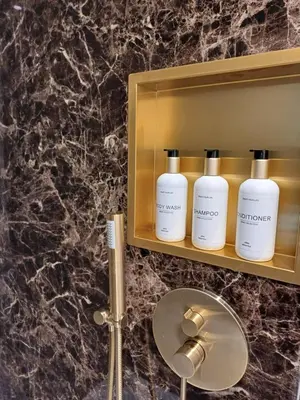 a bathroom with three shampoo bottles on a shelf at Manoir Hamme in Hamme