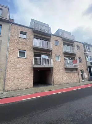 a brick building with a garage on the side of a street at brugsken, Sint-Niklaas in Sint-Niklaas