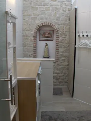 a bathroom with a stone wall and a sink at Wenceslas Cobergher in Scherpenheuvel-Zichem