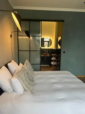 a bedroom with a large white bed with a mirror at Boutique Hotel Marie Marie in Dendermonde