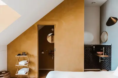 a room with a bed and a room with a staircase at Boutique Hotel Marie Marie in Dendermonde