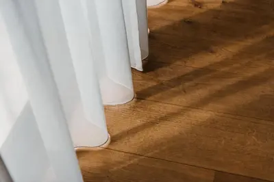 a close up of a wooden floor with white curtains at Boutique Hotel Marie Marie in Dendermonde