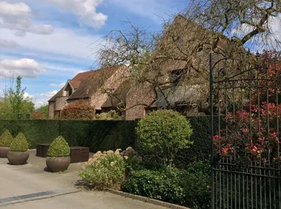 a fence in front of a house with plants at Hotel ABBEY in Grimbergen