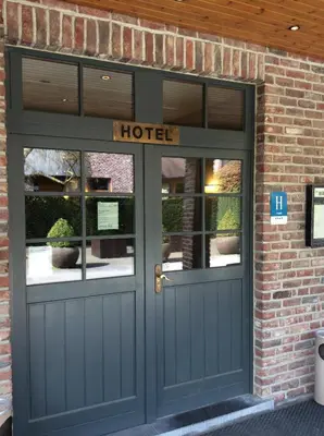 a door to a hotel with a sign on it at Hotel ABBEY in Grimbergen