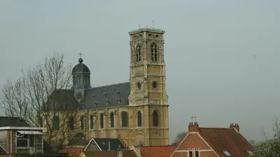 an old church with a clock tower in a town at Hotel ABBEY in Grimbergen