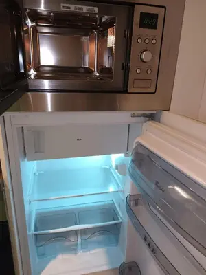 a refrigerator with its door open and a microwave at Gallery Home in Brussels