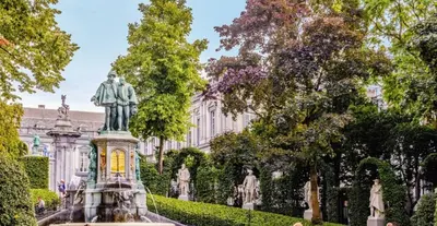 a statue in a garden in front of a building at Un sommeil paisible in Brussels