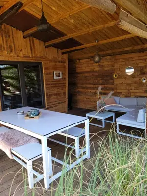 a patio with a white table and chairs at Rustig gelegen chalet Solvo met terras aan het water in Geel