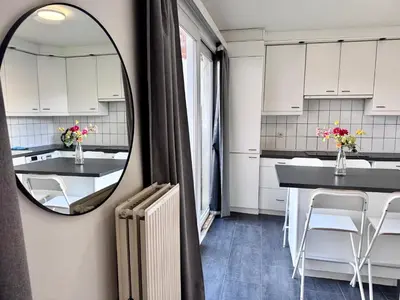 a kitchen with white cabinets and a mirror on the wall at Apartments Bex. in Antwerp