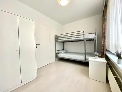 a bedroom with a bunk bed and white cabinets at Apartments Bex. in Antwerp