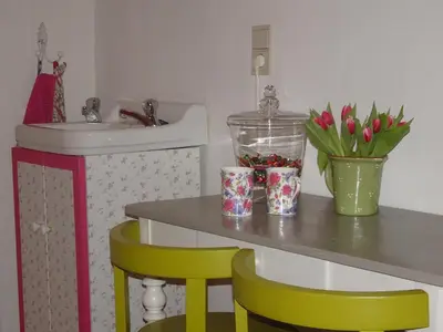 a bathroom with a sink and a table with two chairs at Guesthouse Alizée in Leuven