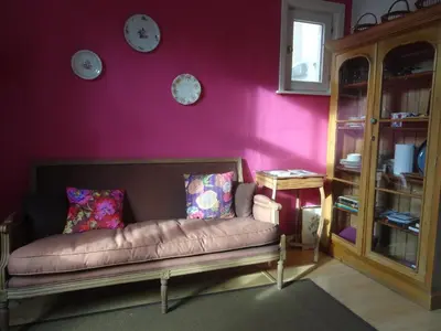 a living room with a couch and a purple wall at Guesthouse Alizée in Leuven