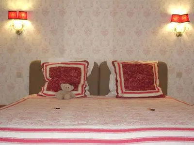 a stuffed teddy bear sitting on a bed with pillows at Guesthouse Alizée in Leuven