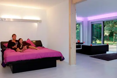 two people sitting on a bed in a bedroom at Nooz - Something Different? in Grobbendonk