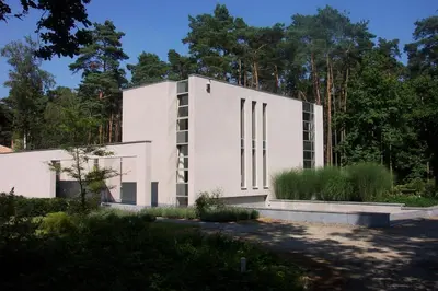 a white building with trees in the background at Nooz - Something Different? in Grobbendonk