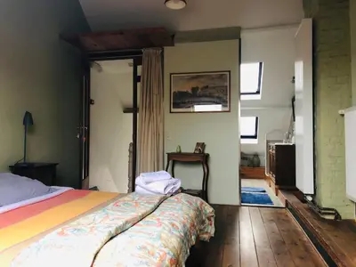 a bedroom with a bed with a colorful blanket at B&B Faja lobi in Ghent